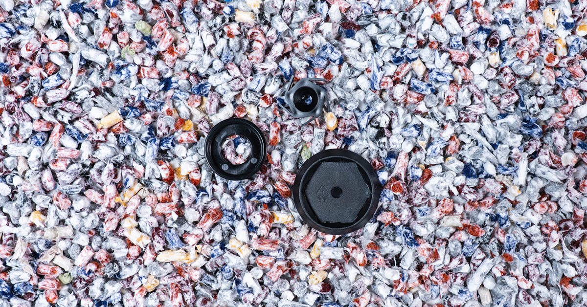 An image of deconstructed SpinFix™ clip with colourful recycled PET pellets. Autex Acoustics® newest sustainable innovation.